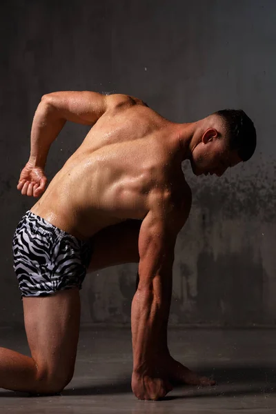 Bodybuilder Pronkt Met Zijn Spieren Figuur Studio Regen — Stockfoto