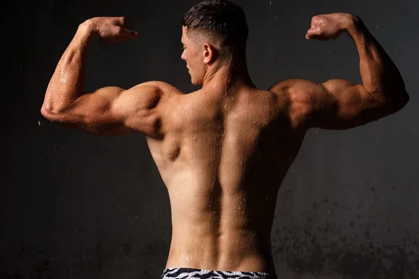 Bodybuilder Lässt Muskeln Und Figur Studio Regen Zur Schau Stellen — Stockfoto