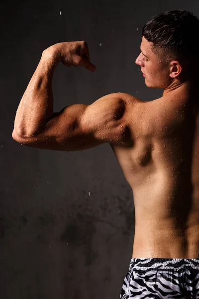 Fisiculturista Ostenta Seus Músculos Figura Estúdio Chuva — Fotografia de Stock