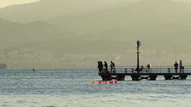 Deniz suyunda komik renkli balonlar ve balık tutan insanlar. 