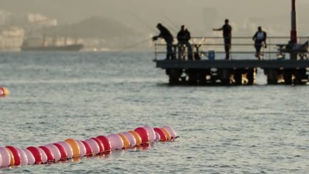 Αστεία Πολύχρωμα Μπαλόνια Στο Θαλασσινό Νερό Και Άνθρωποι Αλιείας Σιλουέτα — Αρχείο Βίντεο
