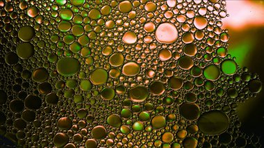 Soyut Renkli Gıda Yağı Kabarcıkları ve Küreler Su Yüzeyi Makro Fotoğrafçılığına Akıyor