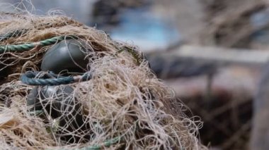 Balıkçı rıhtımdaki balıkçı teknesinde balık ağlarını tamir ediyor.