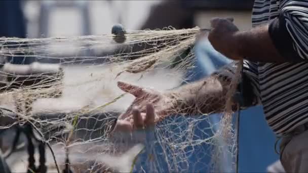 漁師がドックビデオで漁船の魚網を修復しています — ストック動画