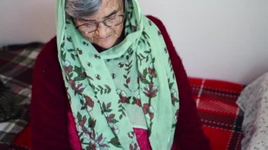 Din. Müslüman, yaşlı bir kadın. Yatağında dua ediyor.