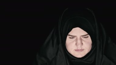 Siyah dua kıyafetleri ve türban takan genç Müslüman kadın.
