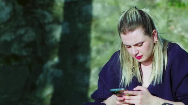 Молода Блондинка Використовує Свій Мобільний Телефон Природі — стокове відео