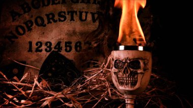 Büyücülük tahtasındaki korkunç kafatası ve mumlar.