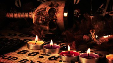 Büyücülük tahtasındaki korkunç kafatası ve mumlar.