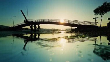 Gün batımında Denizin Üzerinde Bir Köprüyü Geçen İnsanlar Silueti