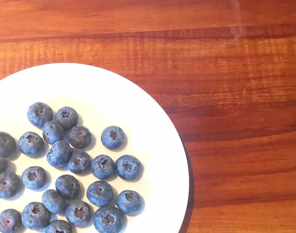 Weiße Teller Mit Üppigen Blaubeeren Stehen Auf Einem Natürlichen Holztisch — Stockfoto