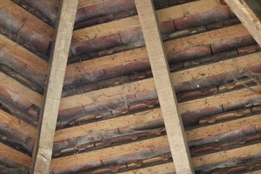 Çatının iç kısmının mimari görüntüsü tuğlaları ve ahşap destekleri gösteriyor. Yüksek kalite fotoğraf