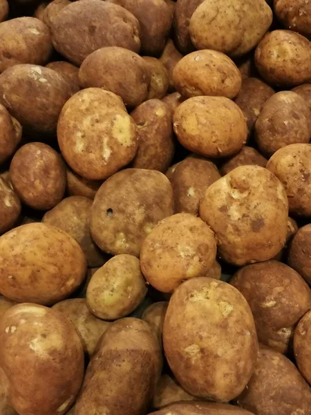 Full frame vegetable background of brown unwashed fresh unpeeled potatoes. High quality photo