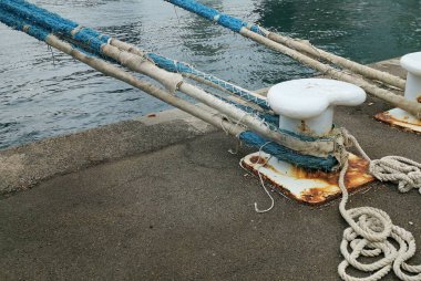 Rusty Harbourside Bollard 'da su kenarında yıpranmış bir ip var. Yüksek kalite fotoğraf