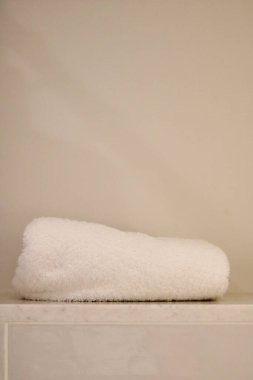 Vertical image of clean white towel on shelf with copy space. High quality photo