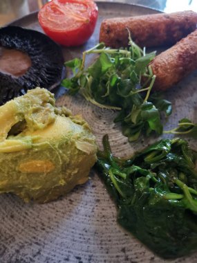 Vertical image of vegetarian breakfast with avocado, lentil sausages, mushroom. High quality photo