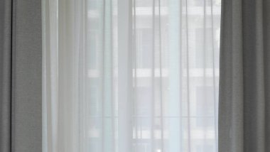 Voile curtain in front of window with grey pleated curtains to either side. High quality photo