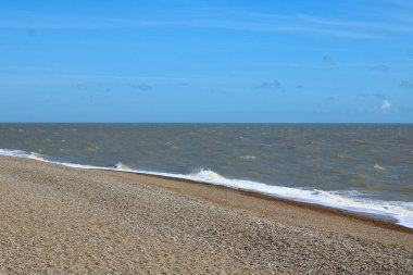Sahilin ön planında kiremitli plaj sahnesi ve arka planında hafif dalgalar. Yüksek kalite fotoğraf