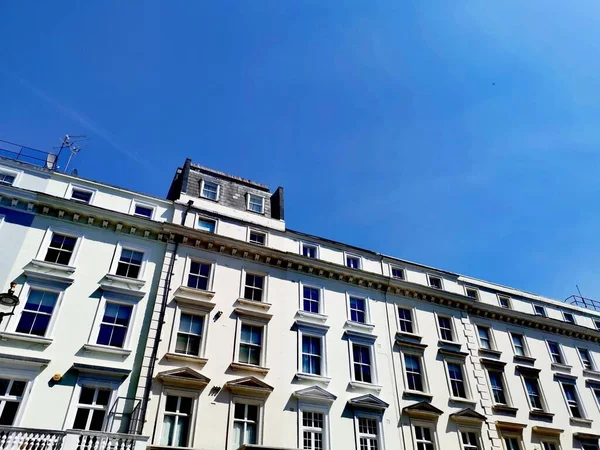 14 Mayıs 2023 - Londra SW1, UK: Dönem binalarının üzerinde mavi gökyüzü olan tipik Londra caddesi. Kopyalama alanı olan yüksek kaliteli fotoğraf.