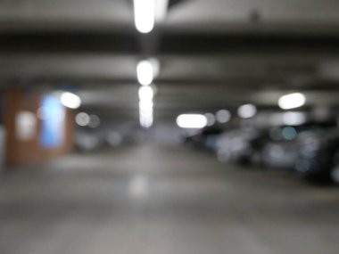 Beyaz ışıklı kapalı otoparkın bulanık görüntüsü. Kopyalama alanı olan yüksek kaliteli fotoğraf.