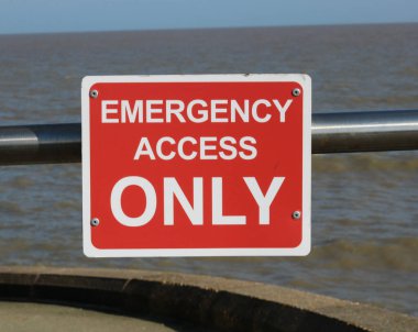 Kırmızı ve beyaz acil durum erişimi sadece denizin önündeki korkuluklara bağlı. Yüksek kalite fotoğraf