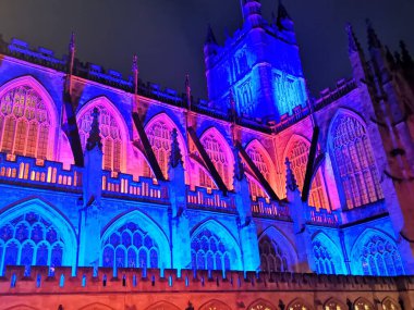 Editorial image of Bath Cathedral UK by night illuminated in bright colours on 16 December 2023. clipart