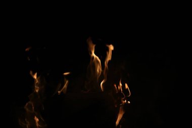 Fotokopi uzayı ile siyah arkaplana karşı sönük turuncu alevler. Yüksek kalite fotoğraf