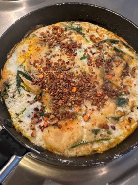 Peynir ve tohum karışımı ile kaplı tavada ıspanaklı omlet manzarası