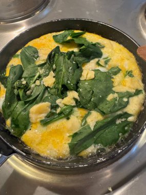 Peynirle kaplı küçük tavada ıspanaklı omlet manzarası. Yüksek kalite fotoğraf