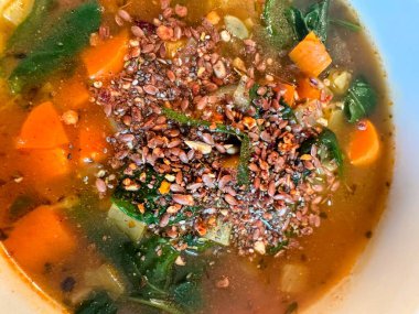 Sıcak kış havucu ve ıspanak çorbası üzerine çeşitli tohumlar ve beyaz kase ya da yemek..