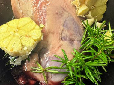 Çiğ kuzu omuzu, biberiye ve yarım sarımsak kafasıyla pişirilmeye hazır. Yüksek kalite fotoğraf.