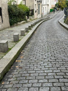 19 Ekim 2024 - Montmartre, Paris, Fransa: uzun kaldırımlı yan cadde boyunca görüş mesafeye doğru yol alıyor