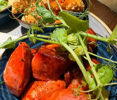 Bezelye filizleriyle süslenmiş baharatlı sosisler. Yüksek kalite fotoğraf