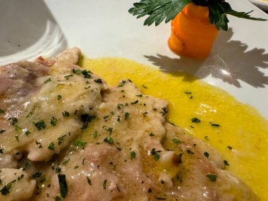 Taze maydanozla süslenmiş tereyağı soslu dana saltimbocca. Yüksek kalite fotoğraf