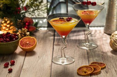 Festive Mimosa cocktails garnished with spiced dried oranges and cranberries, ready for drinking. clipart