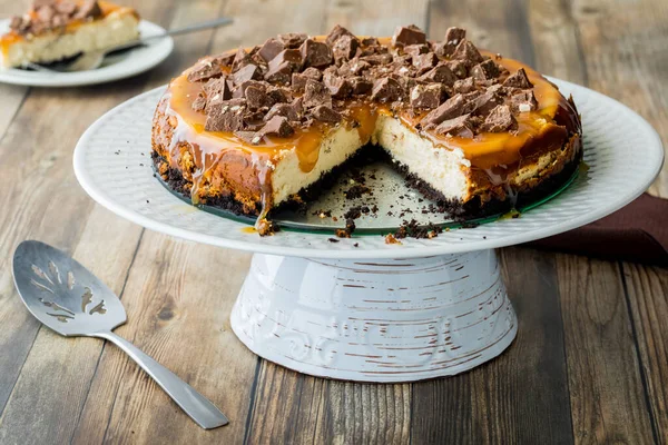 Een Heerlijke Chocolade Karamel Cheesecake Een Voetstuk Met Een Sneetje — Stockfoto