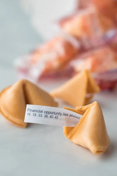 A close up of fortune cookies with a fortune note in the one in front.
