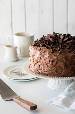 A large homemade low sugar low carb chocolate cake on a pedestal stand, ready for serving. clipart