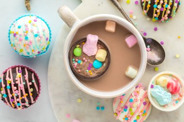 A look into a mug of hot cocoa with a hot cocoa bomb filled with confections for Easter.