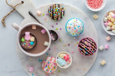 Top down view of a mug filled with hot chocolate served with Easter hot cocoa bombs.