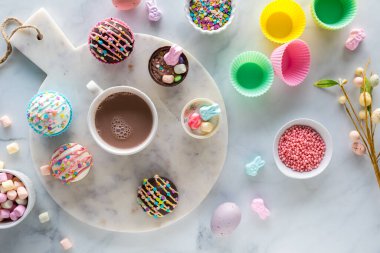Top down view of homemade Easter hot cocoa bombs served with a cup of hot chocolate. 