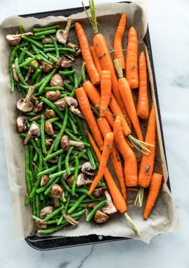 Sebzelerle dolu bir çarşaf tepsisi fırına atılmaya hazır..