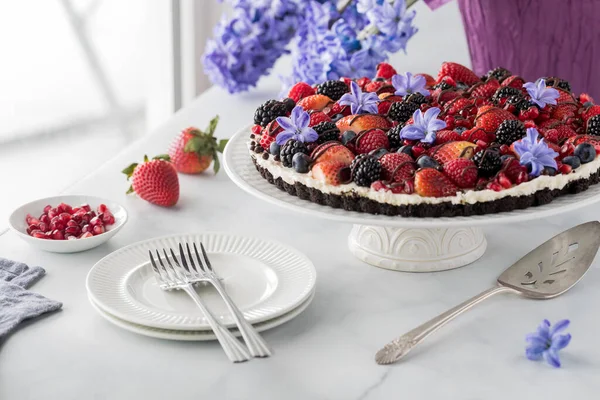 Ein Köstlicher Hausgemachter Gemischter Beerenkäsekuchen Auf Schokoladenbasis Dekoriert Mit Hyazinthenblüten — Stockfoto