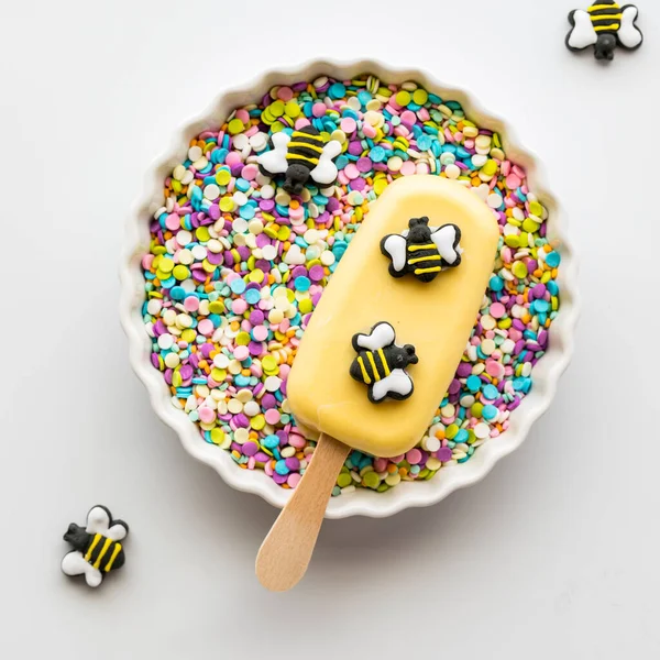 スプリンクルがいっぱいのボウルに食用蜂で飾られた自家製のケーキ 春と夏のコンセプト — ストック写真