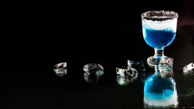 Siyah Hawai jant tuzlu mavi margarita, siyah arka planda, buzlu cama yansıyor..