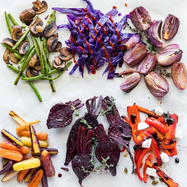 stock image Top down view of groups of steamed or roasted colourful vegetables on parchment paper. 