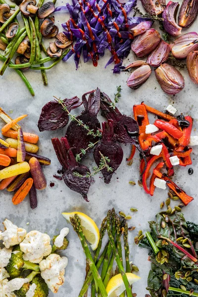 stock image Top down view of messy groups of roasted, steamed and sauteed vegetables on parchment paper.