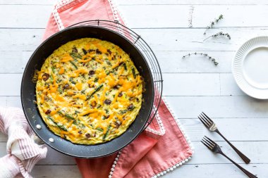 Pastırma ve kuşkonmaz üzerine erimiş peynirli frittata, servis için hazır..