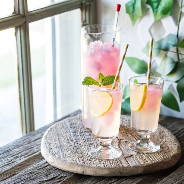 Soğuk ve ferahlatıcı bardaklar ve bir sürahi limonata, pembe limonata buz küpleriyle paylaşmaya hazır..