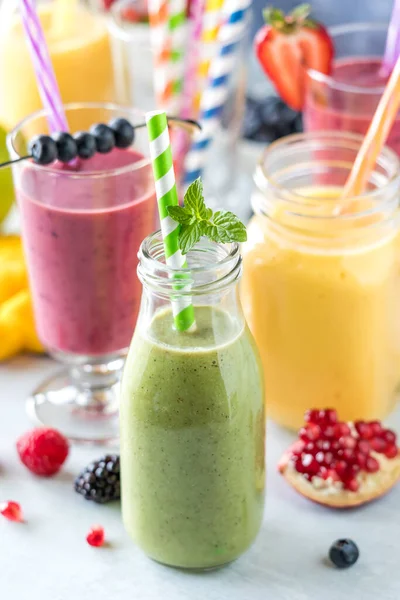 stock image Refreshing fresh fruit smoothies with colourful straws surrounded by juicy fresh fruit. 